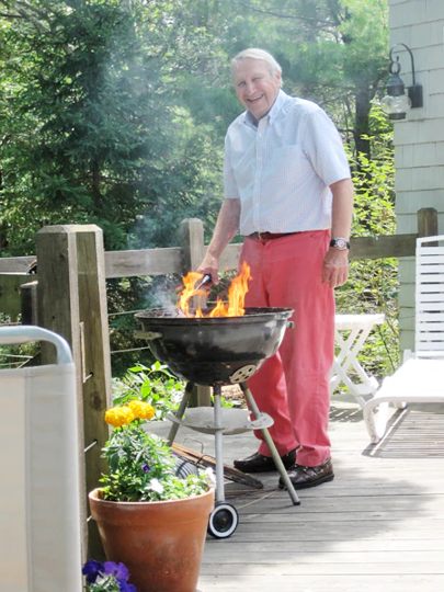 Picture of Brownie grilling outdoors wearing his preppy Nantucket Red trousers, button down shirt and Sperry Docksiders