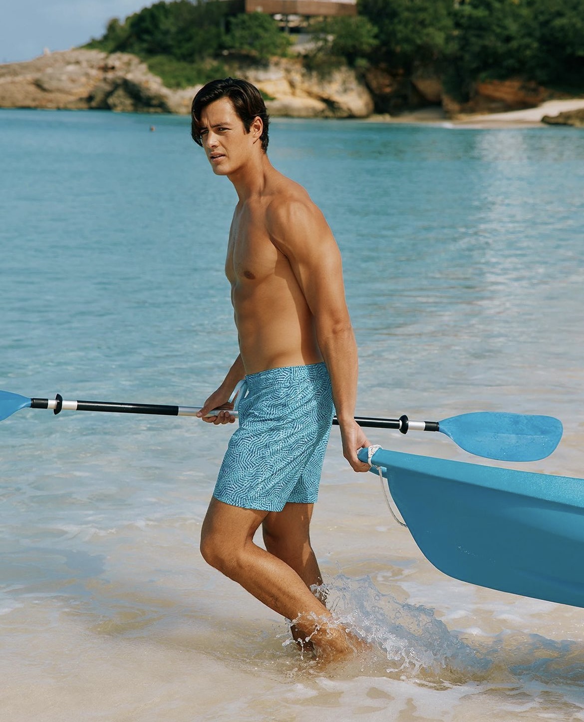 An image from Southern Tide showing a man entering the water with a paddle and kayak
